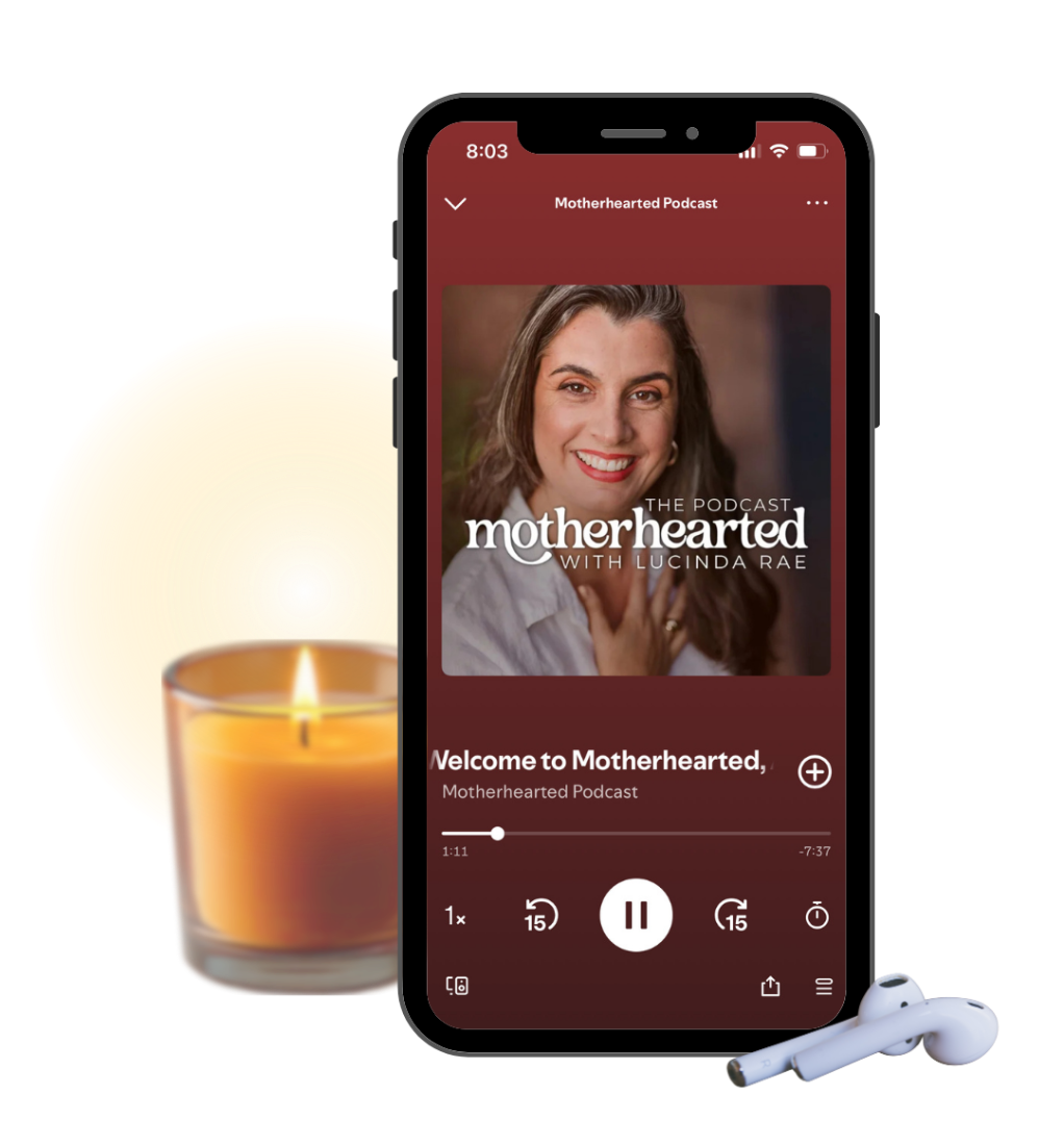 Motherhearted podcast playing on a phone beside a candle
